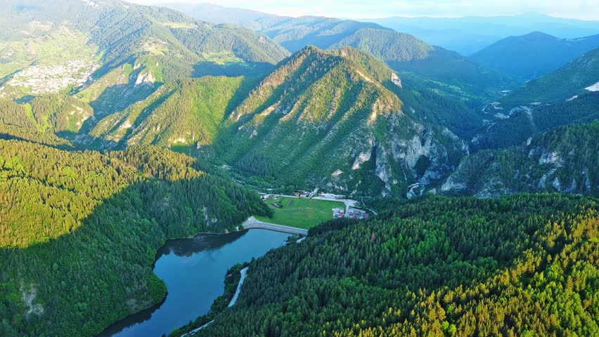 View from rock to town of Smolyan with meadows for cattle walking and houses between mountain range of Rhodope Mountains