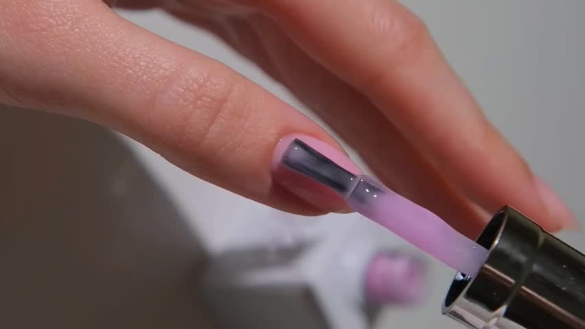 Close Up Video of Young Woman with Smooth Skin Applying Innovative Modern Manicure in Nail Salon