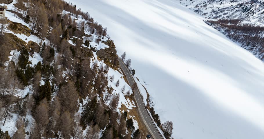 Aerial View of Sils Lake and Snowy Mountain Road in Switzerland Winter Landscape With Trees and Snow-Covered Surface Travel and Tourism Destination. hyperlapse