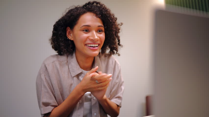 Excited businesswoman raising fists in celebration while looking at laptop screen, achievement, success, remote work victory and positive digital career moment.
