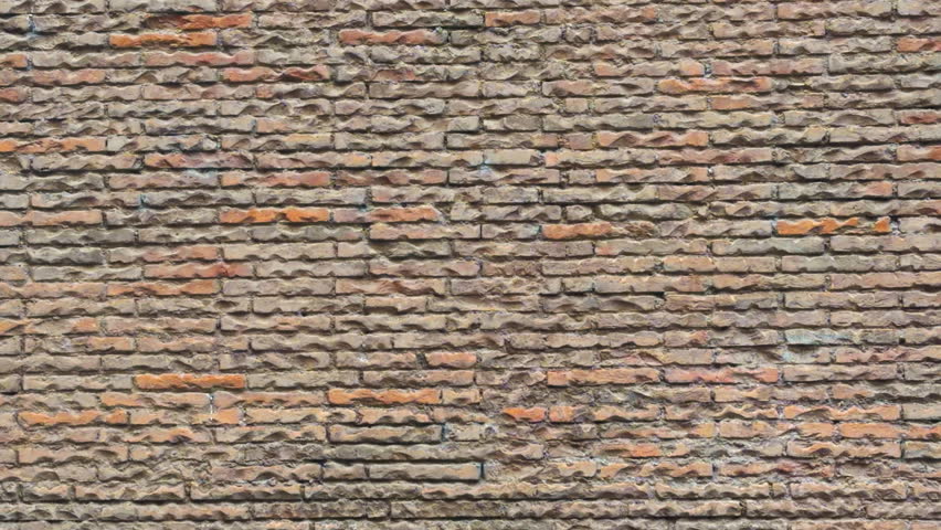 Close-up view of an old brick wall with rough surface and natural color variation. Suitable for background and architectural use.