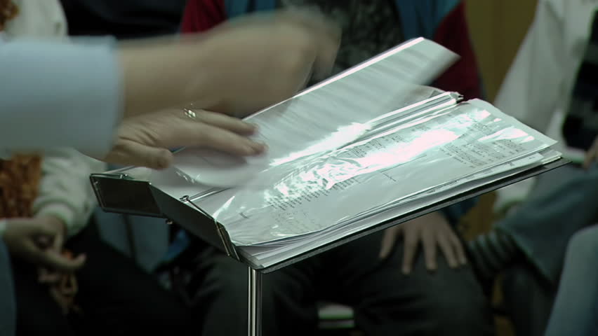 Female Music Teacher Turning Sheet Music on Stand, Choir Practice  