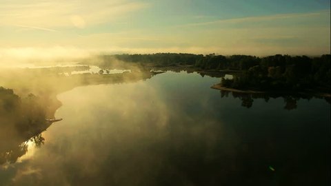 Aerial View. Flying over the beautiful river in clouds . Aerial camera shot. Sunrise. Landscape panorama. Altai, Siberia.