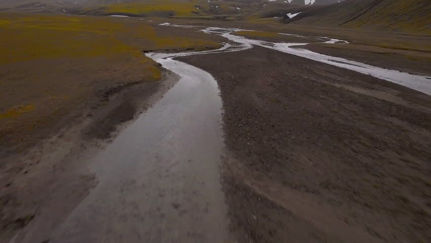Aerial view of a glacial river flowing through a remote and wild valley in the Highlands of Iceland