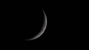 The slender waxing crescent moon appears clear and bright against the deep black void of space as it journeys across the silent and dark evening sky - Powered by Shutterstock - Get 15% off with code: PIKWIZARD15