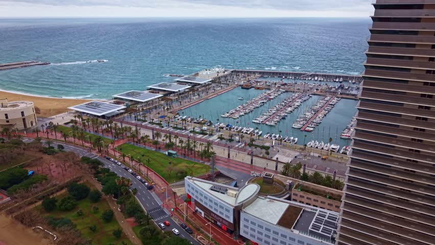 Dramatic fly toward the seaside Barcos de Barcelona marina and open Mediterranean Sea, Barcelona, Spain