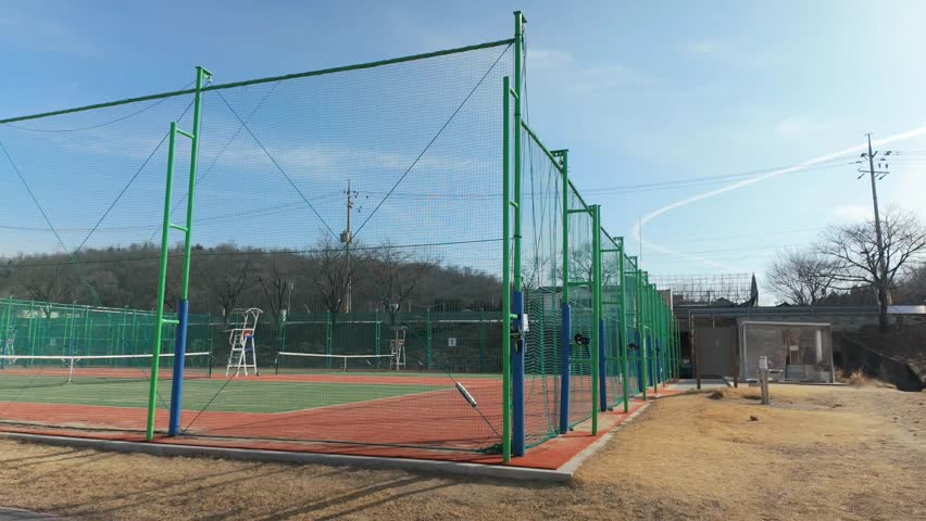 Panning footage of tennis courts located at Tancheon Park in Seoul. An outdoor sports facility in an urban environment, ideal for lifestyle, recreation, and city park concepts.