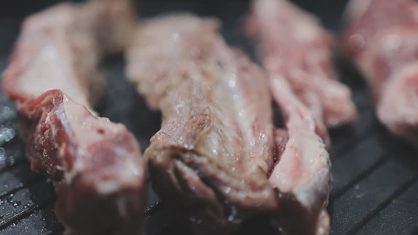 Galbi sizzling Korean BBQ experience showing dynamic cooking action with smoke and grill marks for authentic restaurant scene.