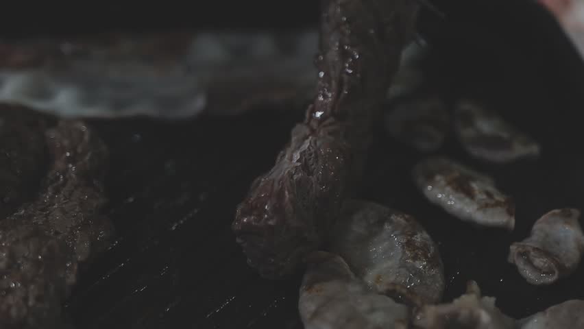 Galbi sizzling Korean BBQ experience showing dynamic cooking action with smoke and grill marks for authentic restaurant scene.