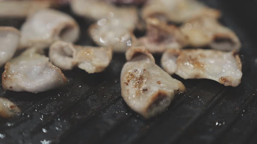 Galbi sizzling Korean BBQ experience showing dynamic cooking action with smoke and grill marks for authentic restaurant scene.
