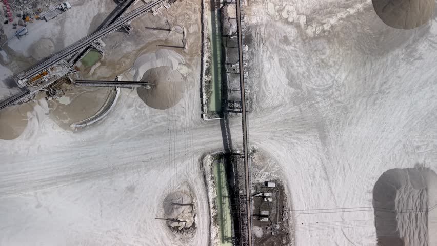 Aerial top down view of an industrial sand quarry with conveyor belts and processing machinery in Florida