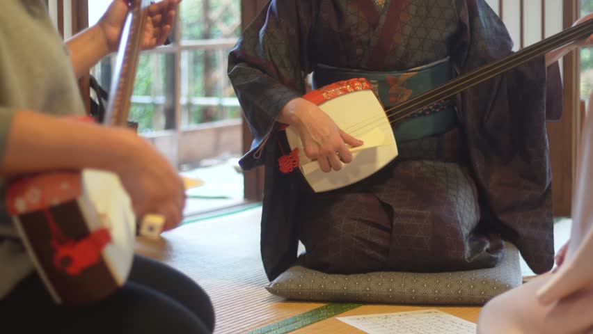 A woman playing the shamisen