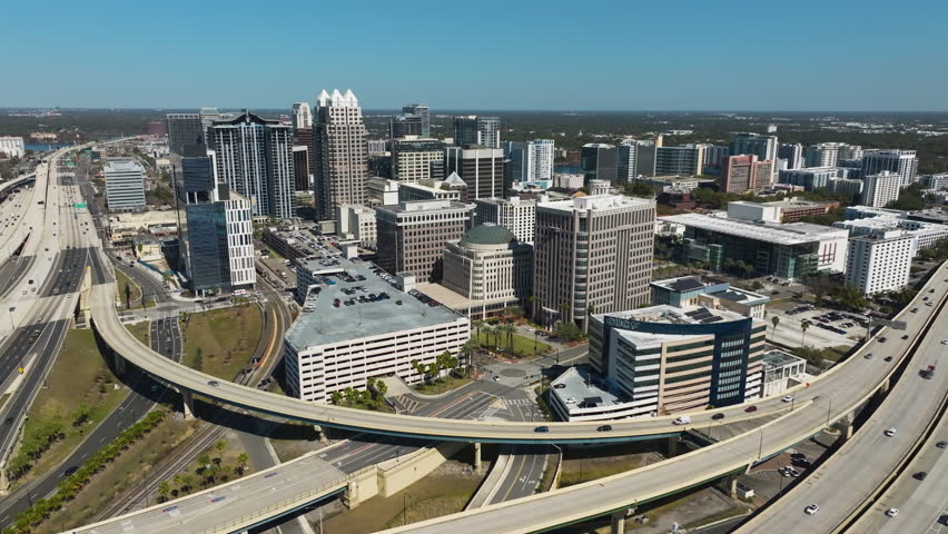 A cinematic aerial perspective captures the energy and forward momentum of downtown Orlando framed by its modern high-rise architecture.