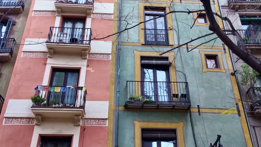 Traditional Spanish apartment facades with balconies and windows seen from street, Barcelona, Spain