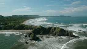 Aerial drone view of rocky headland at Guiones Beach in Nosara, Costa Rica, with waves crashing along the shoreline - Powered by Shutterstock - Get 15% off with code: PIKWIZARD15