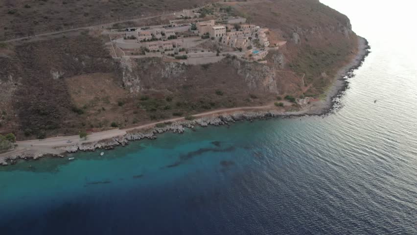 Aerial view of steep coastal village on rocky cliff above the sea Greece
