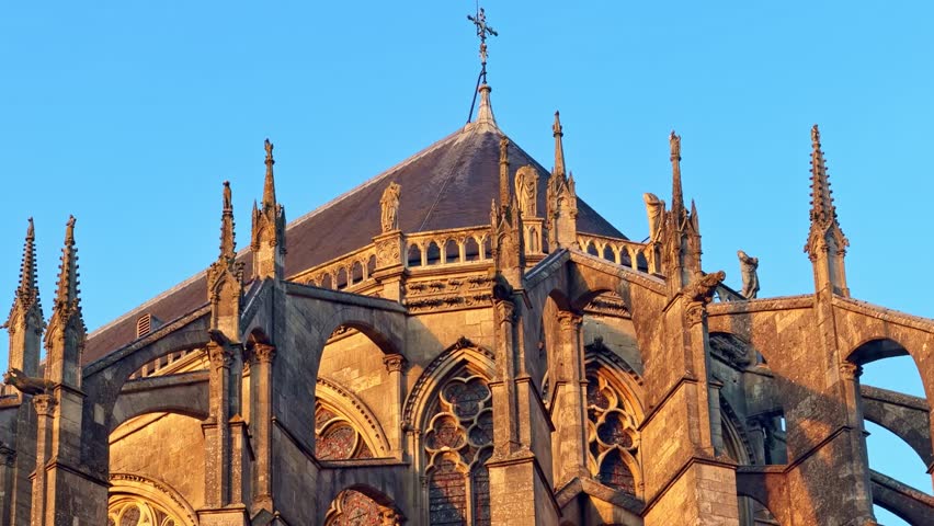 Gothic details of Saint-Julien Cathedral illuminated by golden hour sunset light in Le Mans, France.