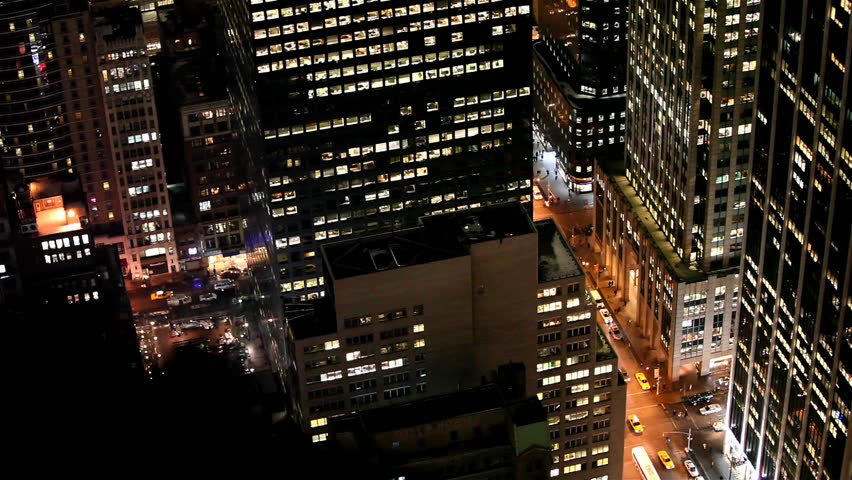 Cars follow traffic under enlighted skyscrapers in Downtown Manhattan, New York