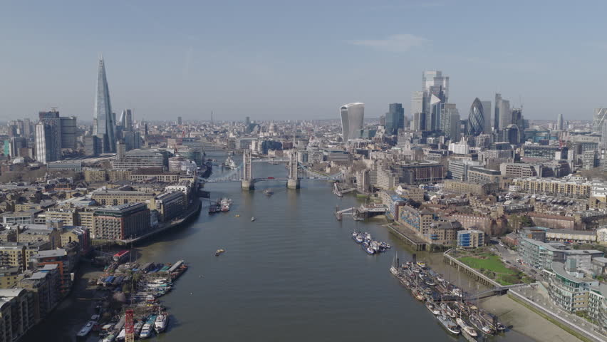 Establishing aerial view of the City of London with Tower Bridge, The Shard and Financial District on bright, sunny day