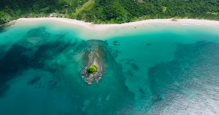 Clear turquoise water and long sandy beach in Nacpan Beach. El Nido, Palawan. Philippines.