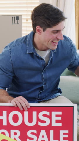 Man, new house and photo with sold sign, dog or hug with smile for fresh start with property investment. People, partner and smartphone with picture for web post, pet animal and board for real estate