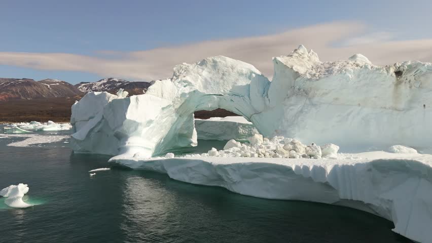 Drone flying through iceberg arch in Saqqaq Greenland