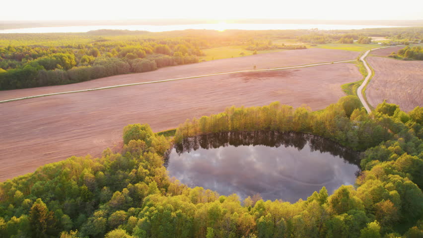 Aerial View of Round Lake in Countryside at Sunset