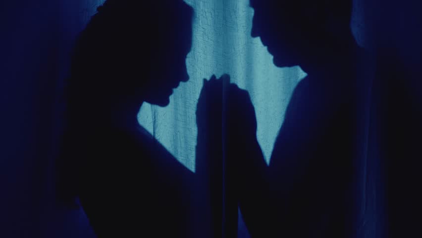 Black shadow silhouette two person, loving couple man face lips kissing female hahds sexy beauty young woman in dark room blue moon light. Adult girl happy guy looking at each other with fall in love