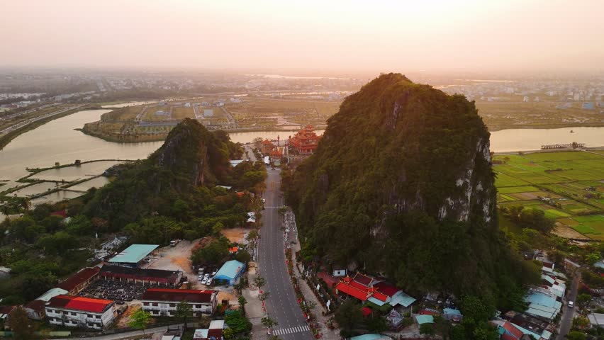 Aerial view of famous quan the am buddhist pagoda at the marble mountains in da nang, vietnam, during a golden sunset.