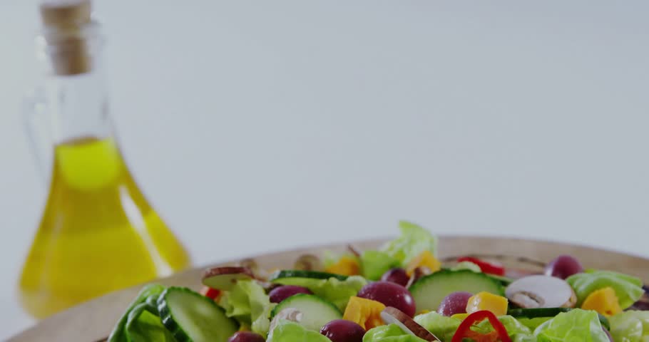 Camera focusing on salad on plate, map overlay appearing and HUD nodes animating to show origins. Greens, medley, vegetables, drizzle, olive, oil, wooden