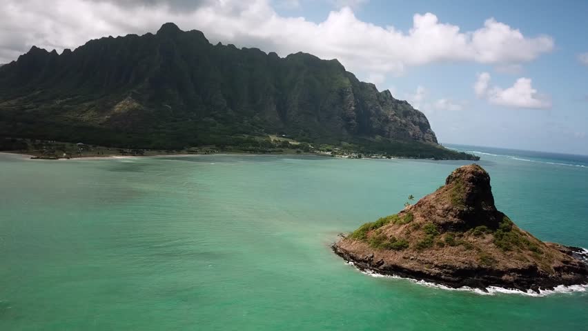 Hawaiian Mountains with an ocean around Kualoa Ranch, Oahu, drone footage, Hawaii. Majestic green mountains and turquoise ocean. Filming location in Hawaii. High quality 4k footage