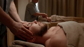 Professional spa therapists performing relaxing head and neck Couples massage treatments on clients covered in warm towels in a tranquil wellness therapy room - Powered by Shutterstock - Get 15% off with code: PIKWIZARD15