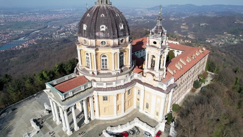 Aerial drone view of the majestic Basilica of Superga with its grand dome and bell tower in Turin, Italy, baroque architecture, hilltop landmark, urban panorama, sunny daylight.