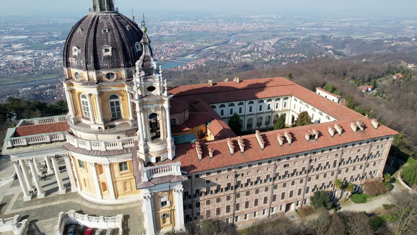 Aerial drone view of the majestic Basilica of Superga and its monastery buildings on the hilltop in Turin, Italy, historic baroque architecture, city panorama, sunny daylight.