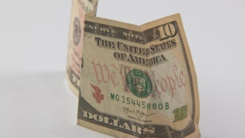 Alexander Hamilton the first U.S. Secretary of the Treasury portrait on printed ten 10 dollar bill of United States of America cash and printed treasury bills in close up and studio slo mo slow motion