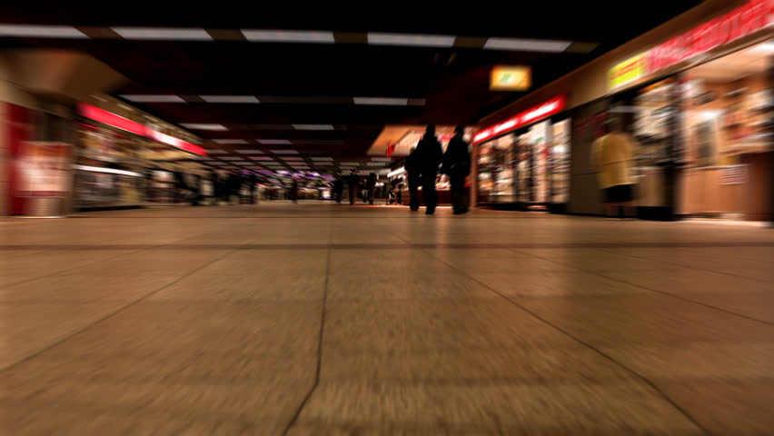 Timelapse of people in a underground subway station with shops and people