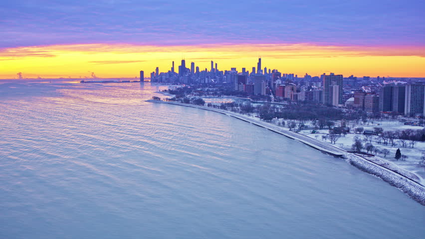 Dramatic aerial shot sweeping across urban skyline beside Lake Michigan