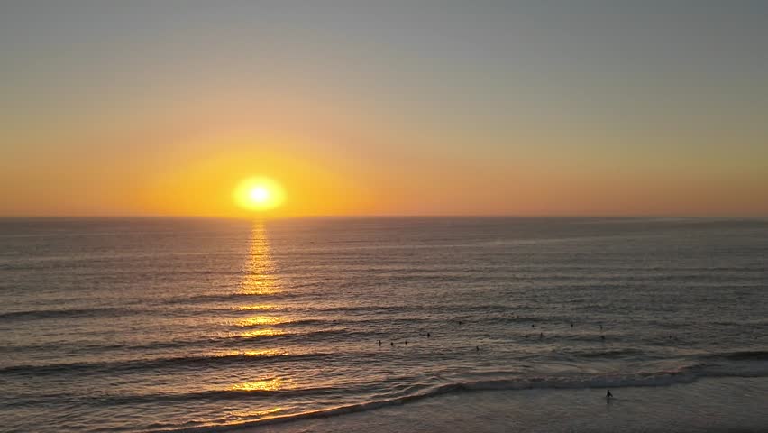 California surfers marvel at the majestic sunset waning over the Pacific Ocean horizon in Dana Point, California.