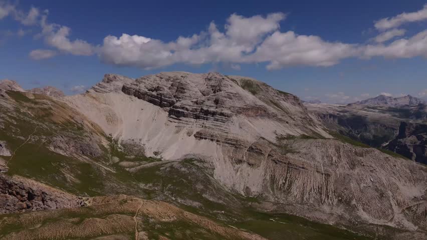 Drone footage of the Dolomites, showcasing jagged mountain peaks, rocky cliffs, and vast alpine terrain, emphasizing the raw and dramatic beauty of northern Italy’s mountains.