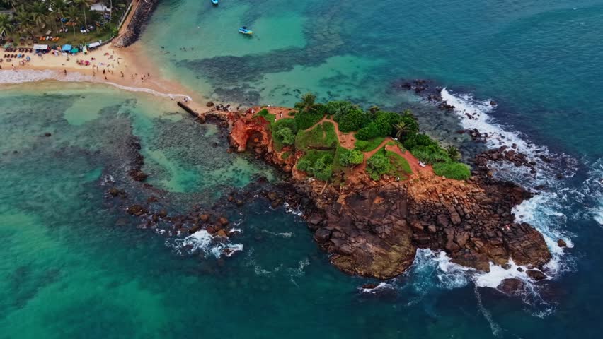 Cinematic drone pan around vibrant parrot rock in Sri Lanka at sunset