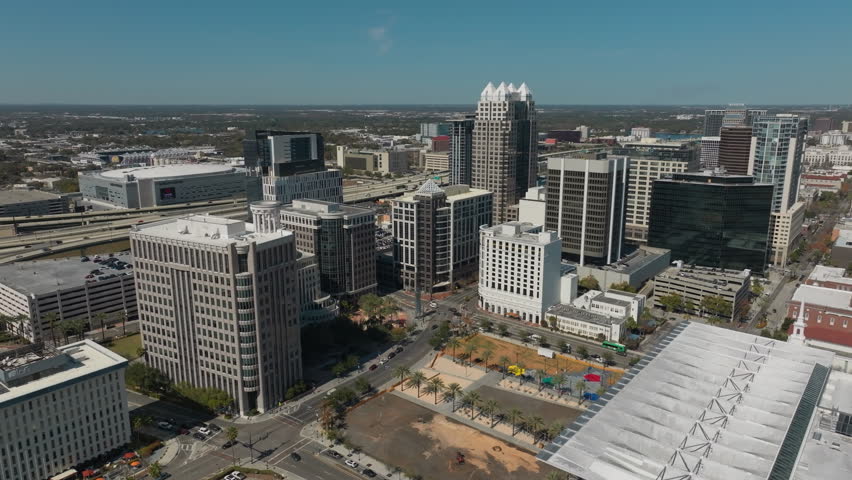 A sweeping drone view reveals downtown Orlando’s glass-and-steel skyline rising confidently above the city’s vibrant urban core.