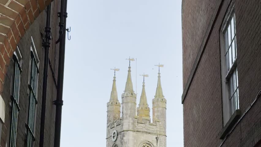Historic Church Tower Framed by Brick Buildings in Ashford England