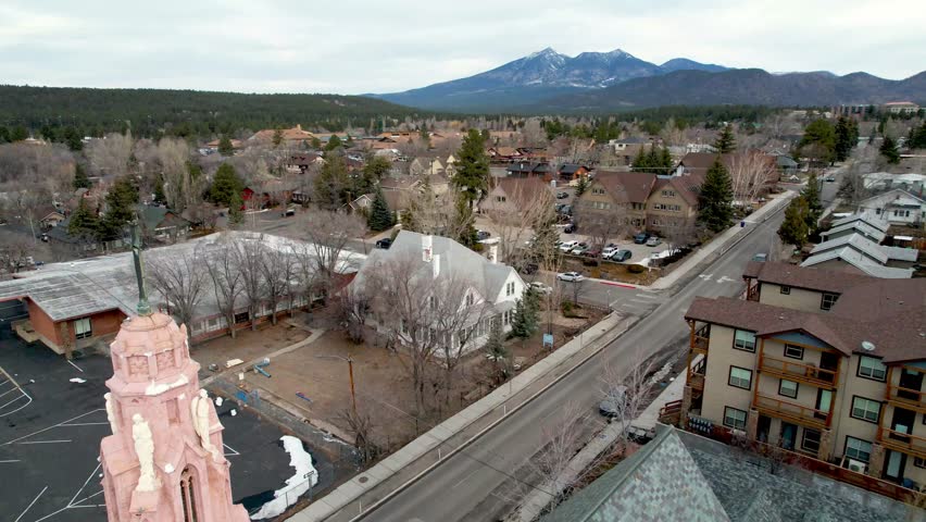 Cross Atop church aerial in flagstaff arizona with San Francisco Peaks in Background