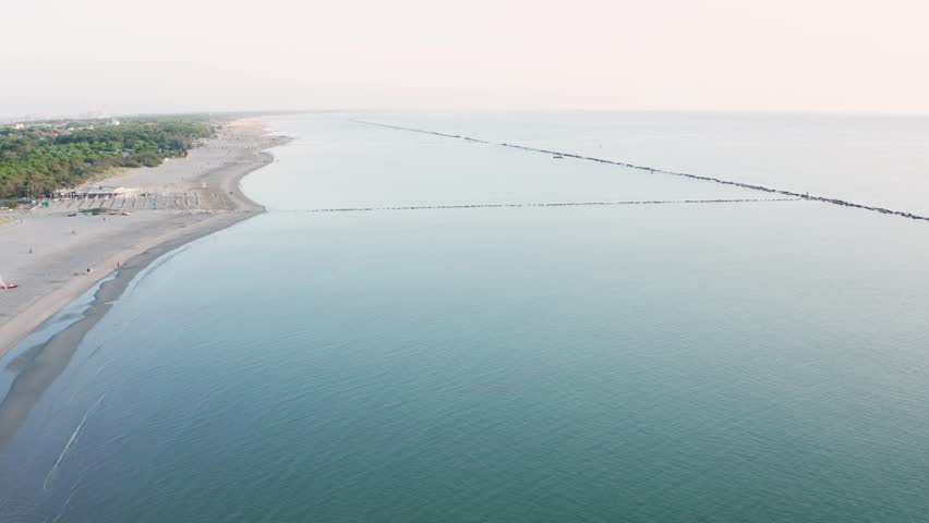 Aerial view of sandy beach with umbrellas,gazebos and town.Summer vacation concept.Lido Adriano town,Adriatic coast, Emilia Romagna,Italy.