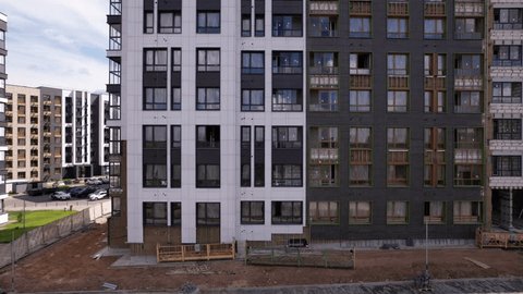 Backward Descending Drone Shot along Apartment Buildings