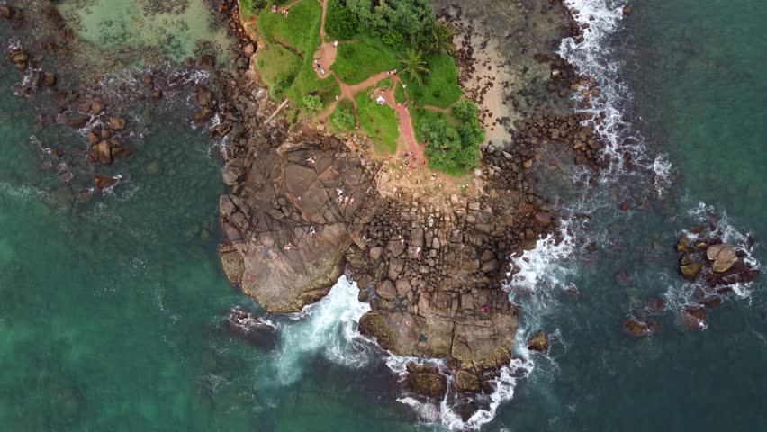 Aerial Drone Birds Eye View Of Tropical Island Surrounded By Rocky Shore And Blue Ocean Water In Scenic Sri Lanka