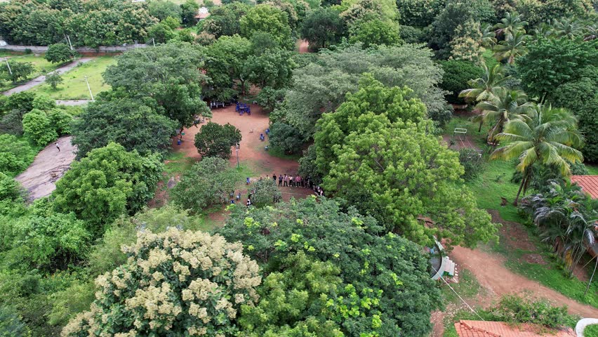 Aerial view of adventurers gathering atop Ramanagara Hill surrounded by lush green forest showcasing scenic trekking trails and vibrant natural landscape