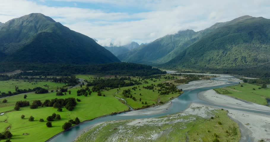 Stunning aerial landscape view of braided river system winding through pristine mountainous terrain of Southern Alps in South Island of New Zealand Aotearoa