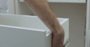 Man repairs a drawer in the kitchen, a man is assembling kitchen furniture, pushing a drawer into a cabinet. - Powered by Shutterstock - Get 15% off with code: PIKWIZARD15