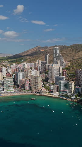 Benidorm coastal skyline with high rise hotels and Mediterranean bay aerial drone view Costa Blanca Spain.